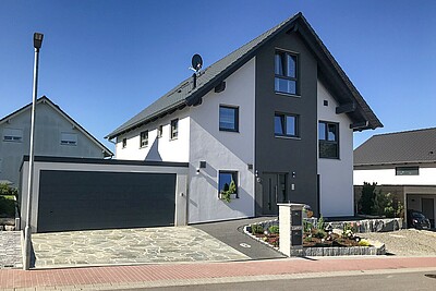 Das Haus der Bauherrenfamilie mit grauem Dach und grauen Akzenten